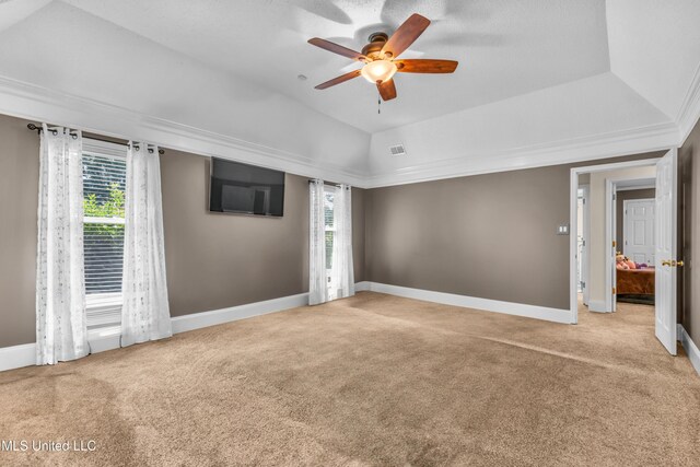 unfurnished bedroom with carpet flooring, baseboards, ceiling fan, lofted ceiling, and a tray ceiling