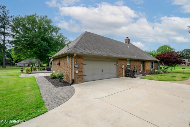 view of side of property with brick siding, a lawn, a garage, and driveway