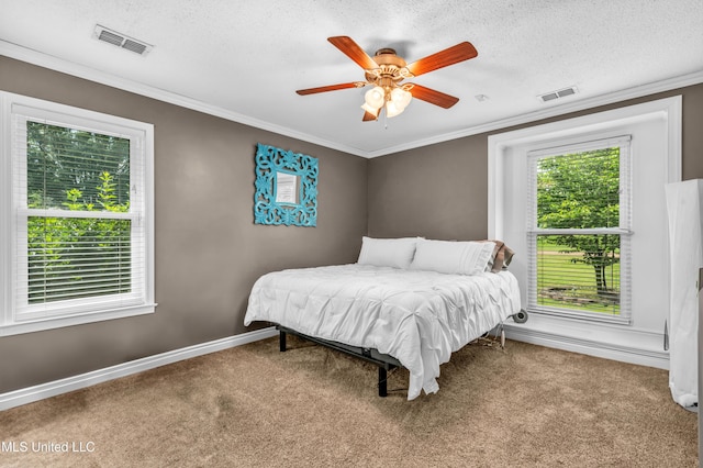 carpeted bedroom featuring baseboards, a textured ceiling, ceiling fan, and crown molding