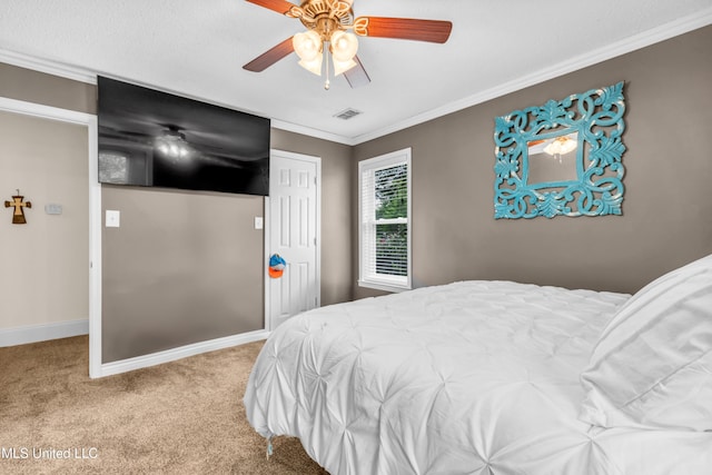 carpeted bedroom featuring ornamental molding, baseboards, ceiling fan, and a closet