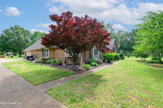 view of property exterior with brick siding, a yard, an attached garage, and concrete driveway