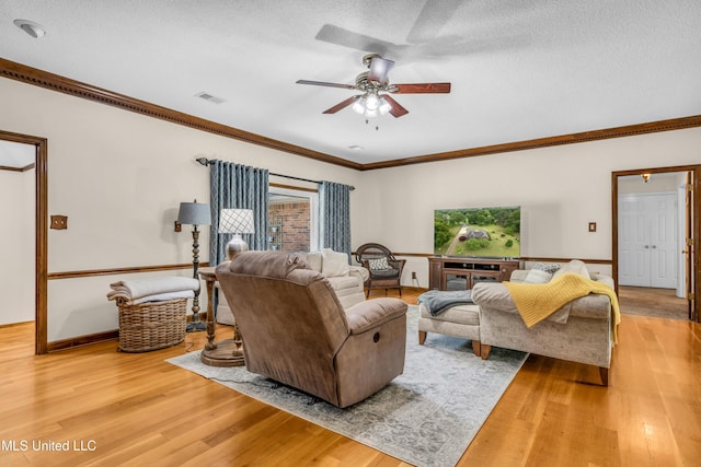 living room with crown molding, light wood finished floors, a ceiling fan, and a textured ceiling