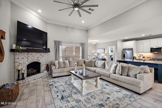 living area featuring recessed lighting, a fireplace, visible vents, ornamental molding, and light wood finished floors