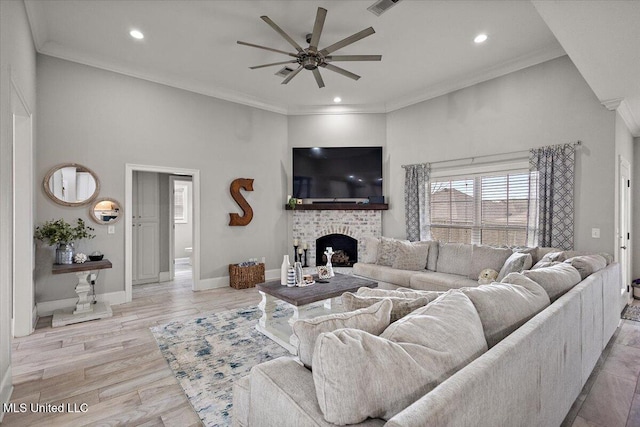 living room with ceiling fan, recessed lighting, a fireplace, baseboards, and crown molding