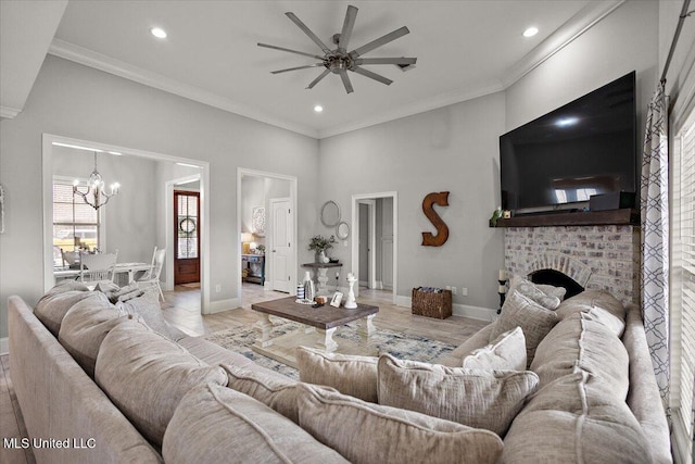 living area with a fireplace, crown molding, recessed lighting, baseboards, and ceiling fan with notable chandelier