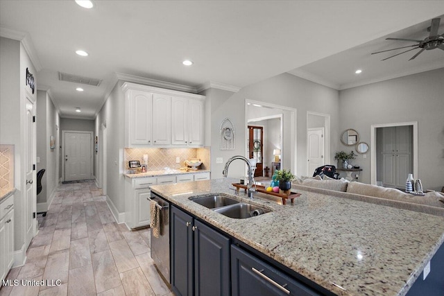 kitchen featuring visible vents, open floor plan, white cabinets, a sink, and dishwasher