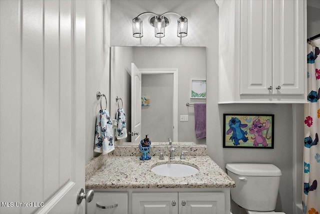 bathroom featuring curtained shower, vanity, and toilet