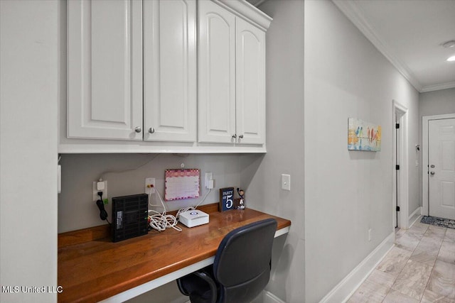 office with built in study area, crown molding, and baseboards