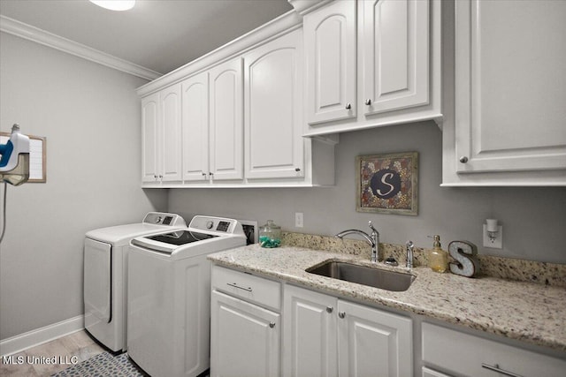 laundry area featuring cabinet space, crown molding, light wood-style floors, separate washer and dryer, and a sink