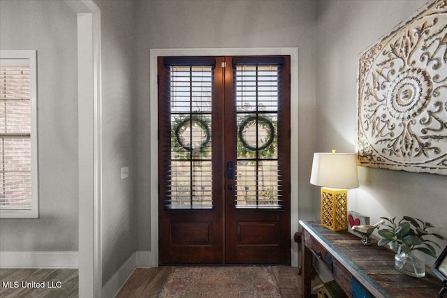 foyer with french doors, baseboards, and wood finished floors