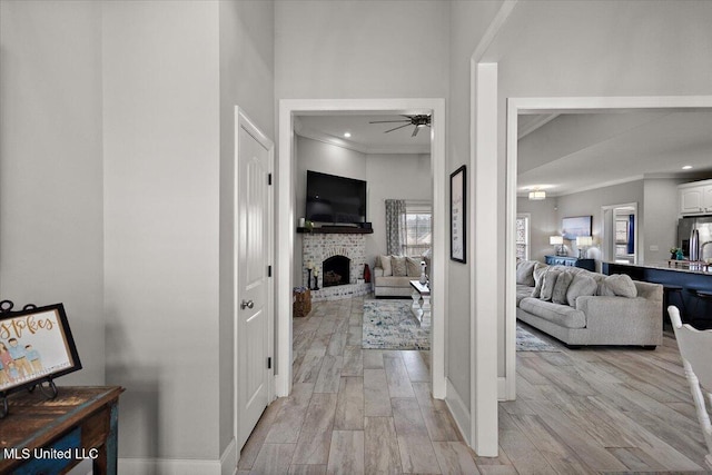 hall featuring light wood-style floors, recessed lighting, crown molding, and baseboards