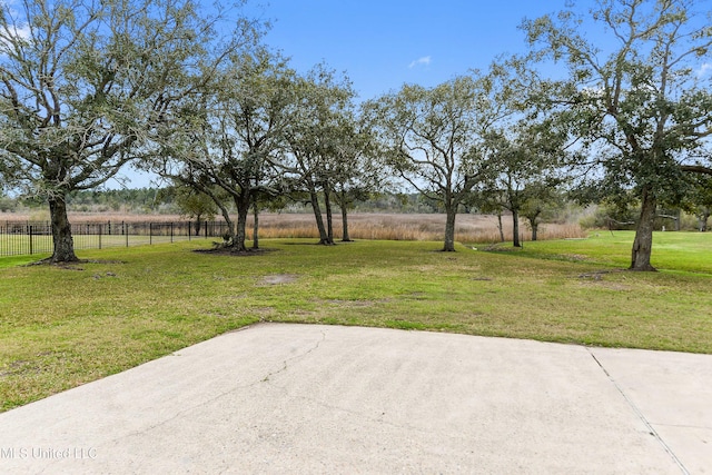 view of yard with a patio area, fence, and a rural view