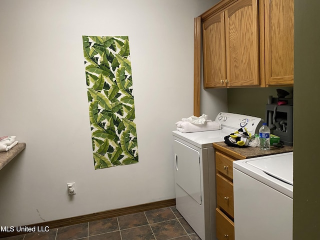 clothes washing area featuring cabinets and washer and dryer