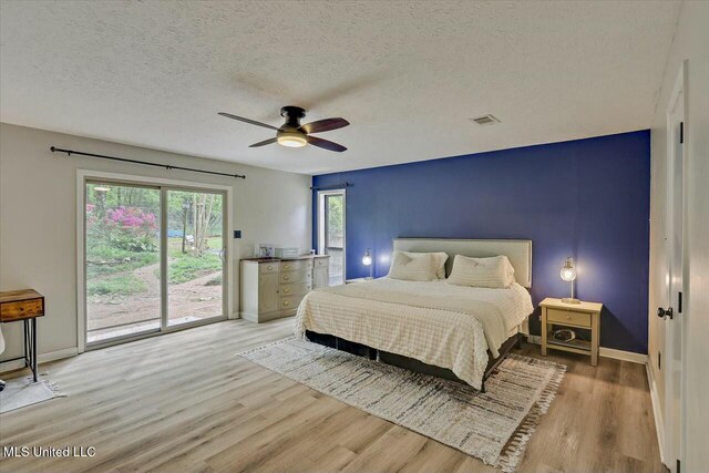 bedroom with baseboards, a textured ceiling, access to outside, and wood finished floors