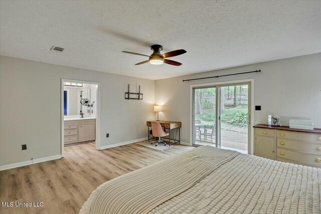 unfurnished bedroom with a textured ceiling, light wood-style flooring, visible vents, baseboards, and access to exterior