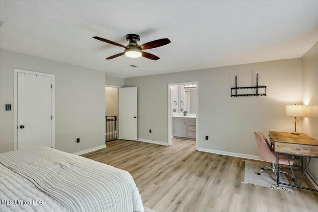 bedroom with ensuite bathroom, baseboards, wood finished floors, a ceiling fan, and a sink
