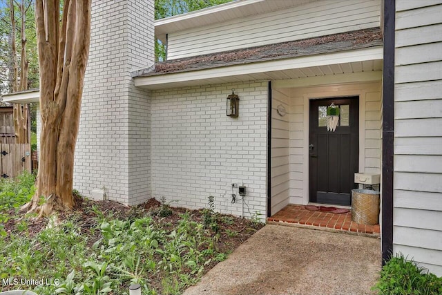 entrance to property featuring brick siding