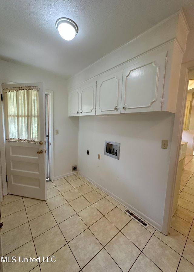 324 Bob White Dr, Canton, MS 39046 - clothes washing area featuring light tile patterned flooring, washer hookup, hookup for an electric dryer, cabinet space, and a textured ceiling
