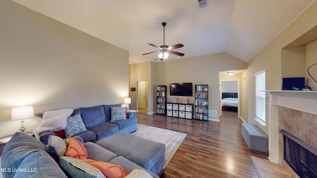 living room featuring ceiling fan, lofted ceiling, dark hardwood / wood-style floors, and a fireplace