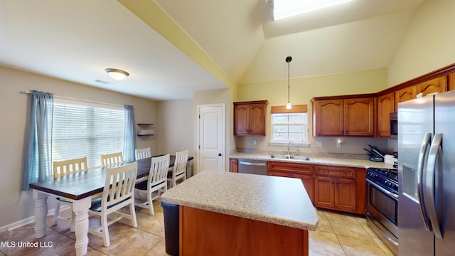 kitchen featuring sink, appliances with stainless steel finishes, a center island, decorative light fixtures, and vaulted ceiling