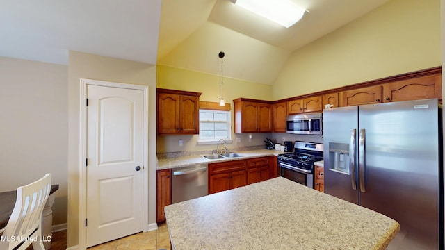 kitchen featuring lofted ceiling, sink, hanging light fixtures, stainless steel appliances, and a center island