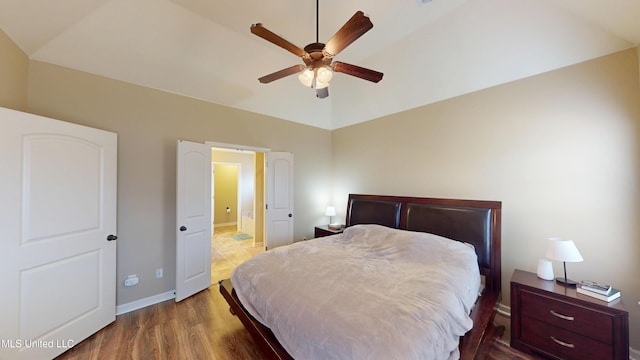 bedroom with hardwood / wood-style flooring, vaulted ceiling, and ceiling fan