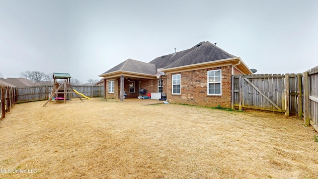 rear view of house featuring a playground