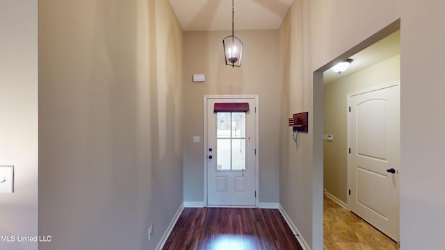 entryway with a towering ceiling and wood-type flooring