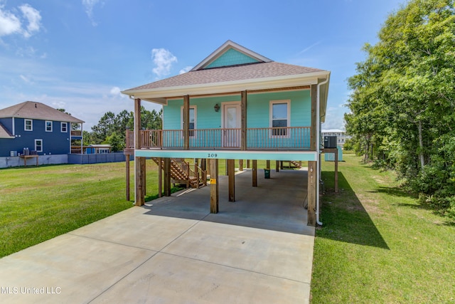 coastal inspired home featuring a carport, a porch, and a front lawn