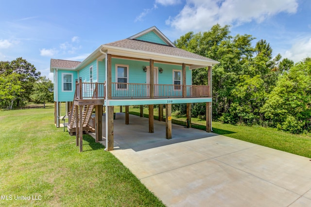 coastal inspired home with a porch, a front lawn, and a carport