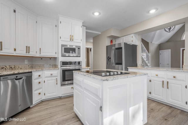 kitchen with white cabinetry, a kitchen island, light wood-type flooring, and appliances with stainless steel finishes