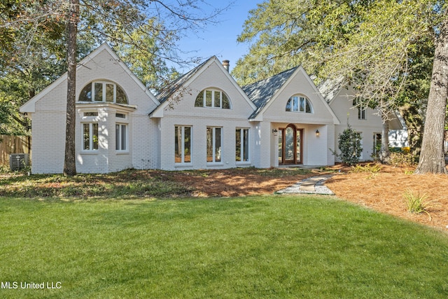 view of front of property with central AC unit and a front yard