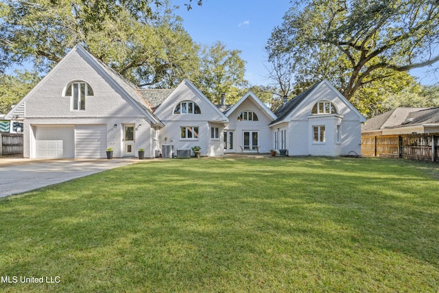 view of front of property featuring cooling unit, a front yard, and a garage