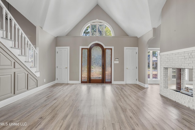 entryway featuring light wood-type flooring and high vaulted ceiling