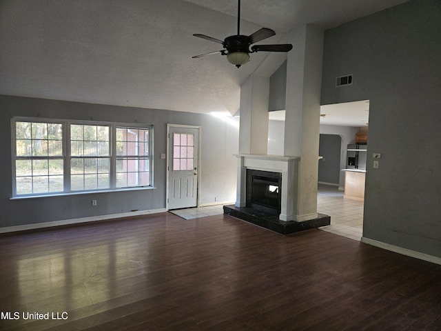 unfurnished living room with ceiling fan, wood-type flooring, and high vaulted ceiling