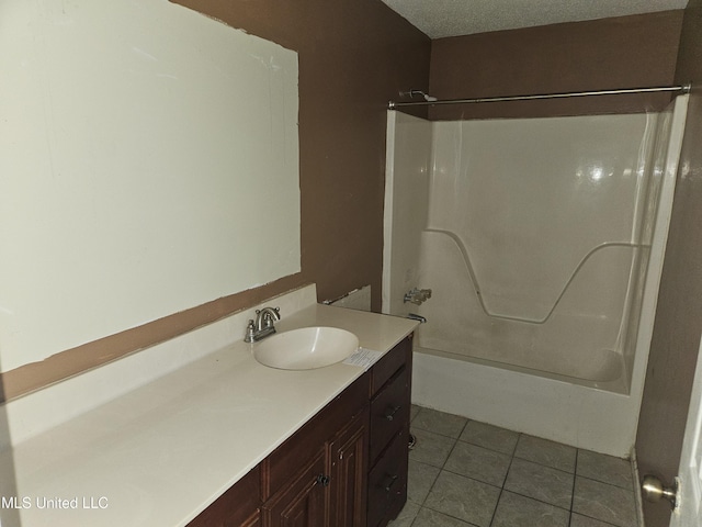 bathroom with vanity, tub / shower combination, tile patterned floors, and a textured ceiling