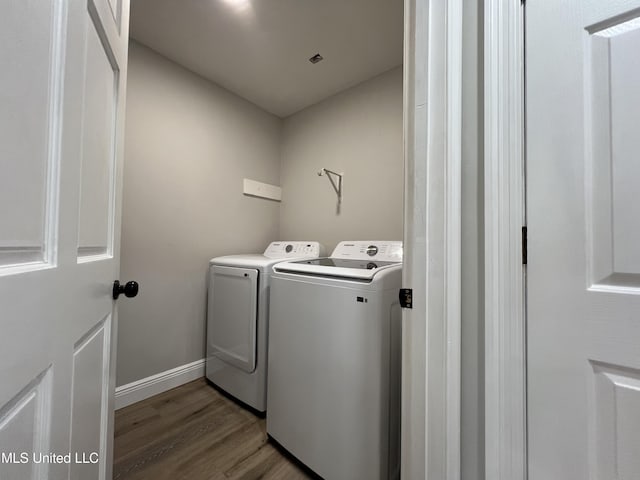 laundry room with hardwood / wood-style flooring and washing machine and clothes dryer