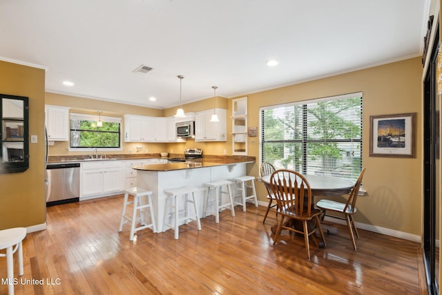 112 Dogwood Ln, Pass Christian, MS 39571 - kitchen featuring stainless steel appliances, a sink, crown molding, a peninsula, and a kitchen bar