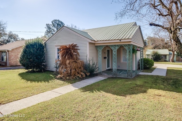 view of front of property featuring a front lawn, covered porch, and metal roof