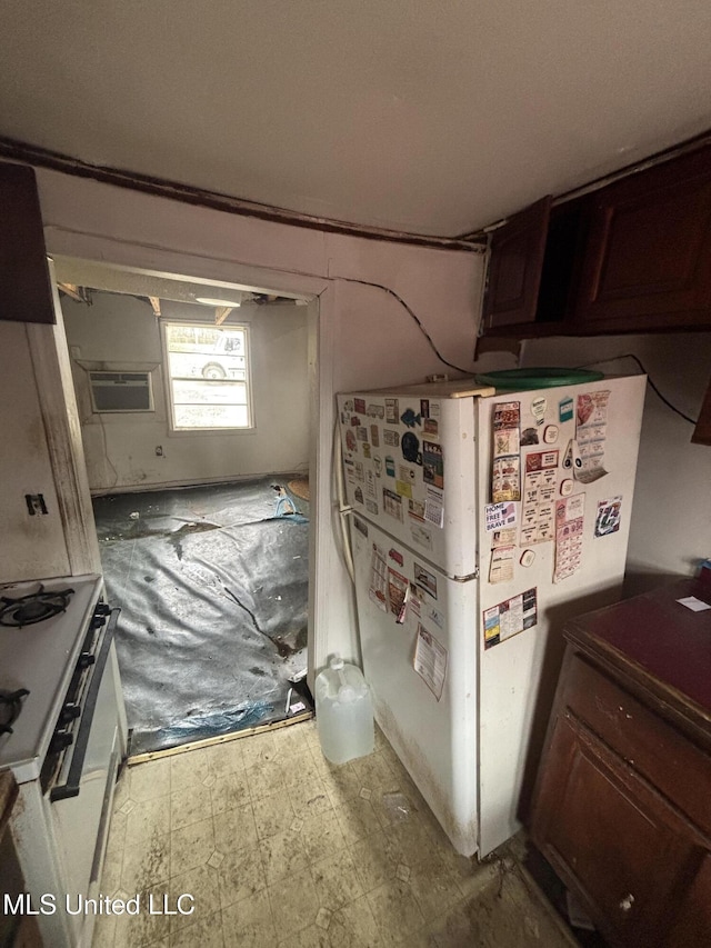 interior space featuring gas range oven, freestanding refrigerator, and tile patterned floors