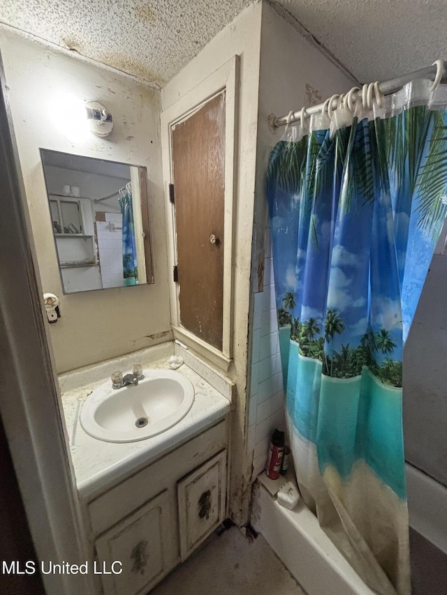 bathroom featuring shower / bath combination with curtain, a textured ceiling, and vanity