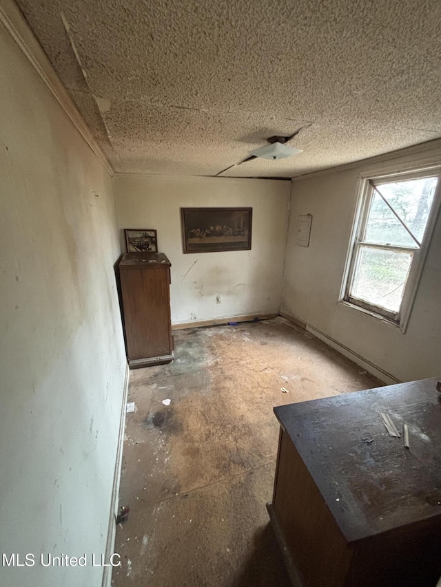 interior space featuring baseboards and a textured ceiling