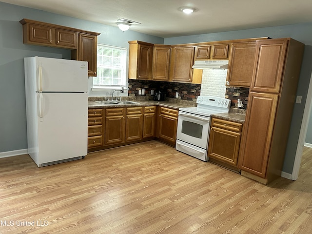 7060 Jefferson St, Bay Saint Louis, MS 39520 - kitchen with a sink, dark countertops, under cabinet range hood, light wood-type flooring, and white appliances