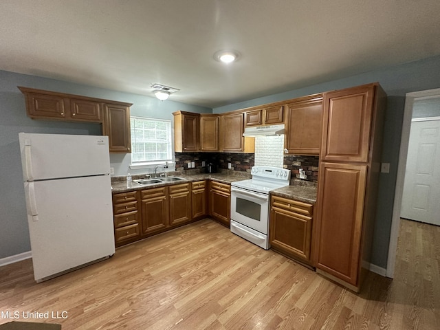 7060 Jefferson St, Bay Saint Louis, MS 39520 - kitchen featuring a sink, under cabinet range hood, light wood-style floors, white appliances, and dark countertops