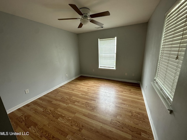 7060 Jefferson St, Bay Saint Louis, MS 39520 - empty room with wood finished floors, visible vents, a ceiling fan, and baseboards