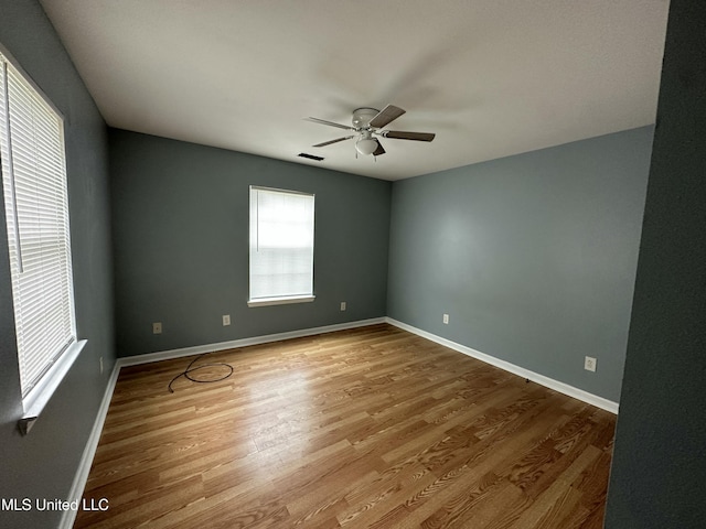 7060 Jefferson St, Bay Saint Louis, MS 39520 - unfurnished room featuring wood finished floors, a ceiling fan, visible vents, and baseboards
