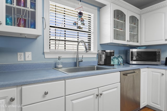 855 Dove Blvd, Bay Saint Louis, MS 39520 - kitchen featuring appliances with stainless steel finishes, glass insert cabinets, and white cabinetry
