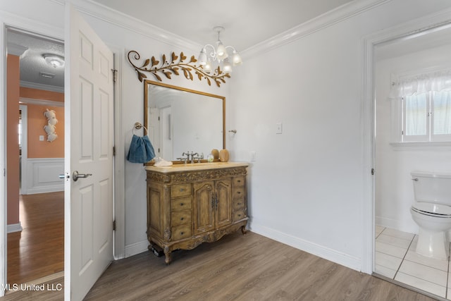 855 Dove Blvd, Bay Saint Louis, MS 39520 - bathroom featuring vanity, a chandelier, wood finished floors, and ornamental molding