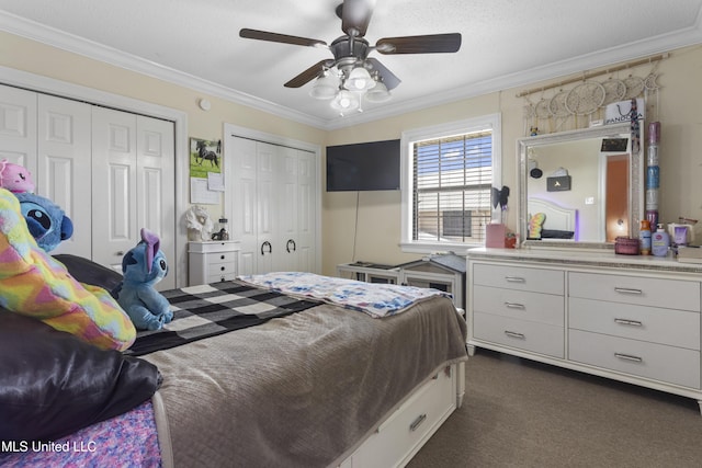 855 Dove Blvd, Bay Saint Louis, MS 39520 - bedroom featuring multiple closets, ornamental molding, dark colored carpet, and a ceiling fan