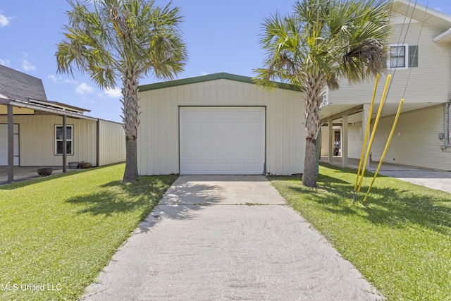 855 Dove Blvd, Bay Saint Louis, MS 39520 - view of front of home with an outdoor structure, a front yard, concrete driveway, and a detached garage